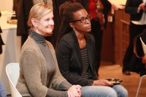 People sitting down and listening at event.